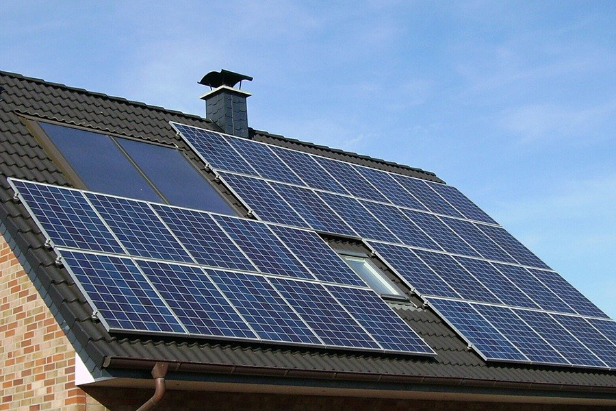 Ein braunes Satteldach eines Einfamilienhauses mit Solarpanelen.
