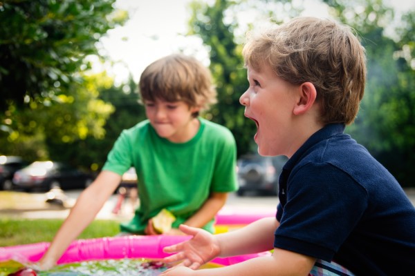 Zwei Kinder spielen und lachen in einem Garten im Sommer